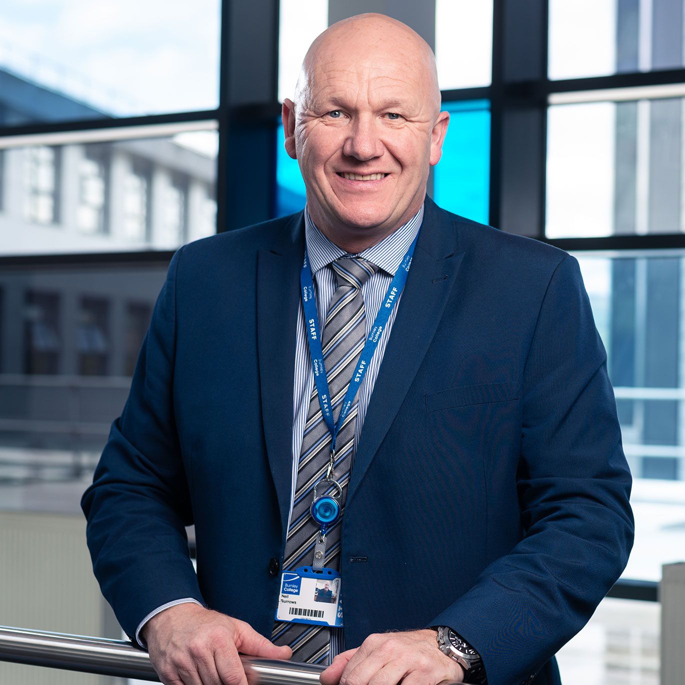 A man stands on an internal balcony at a leading Sixth Form College