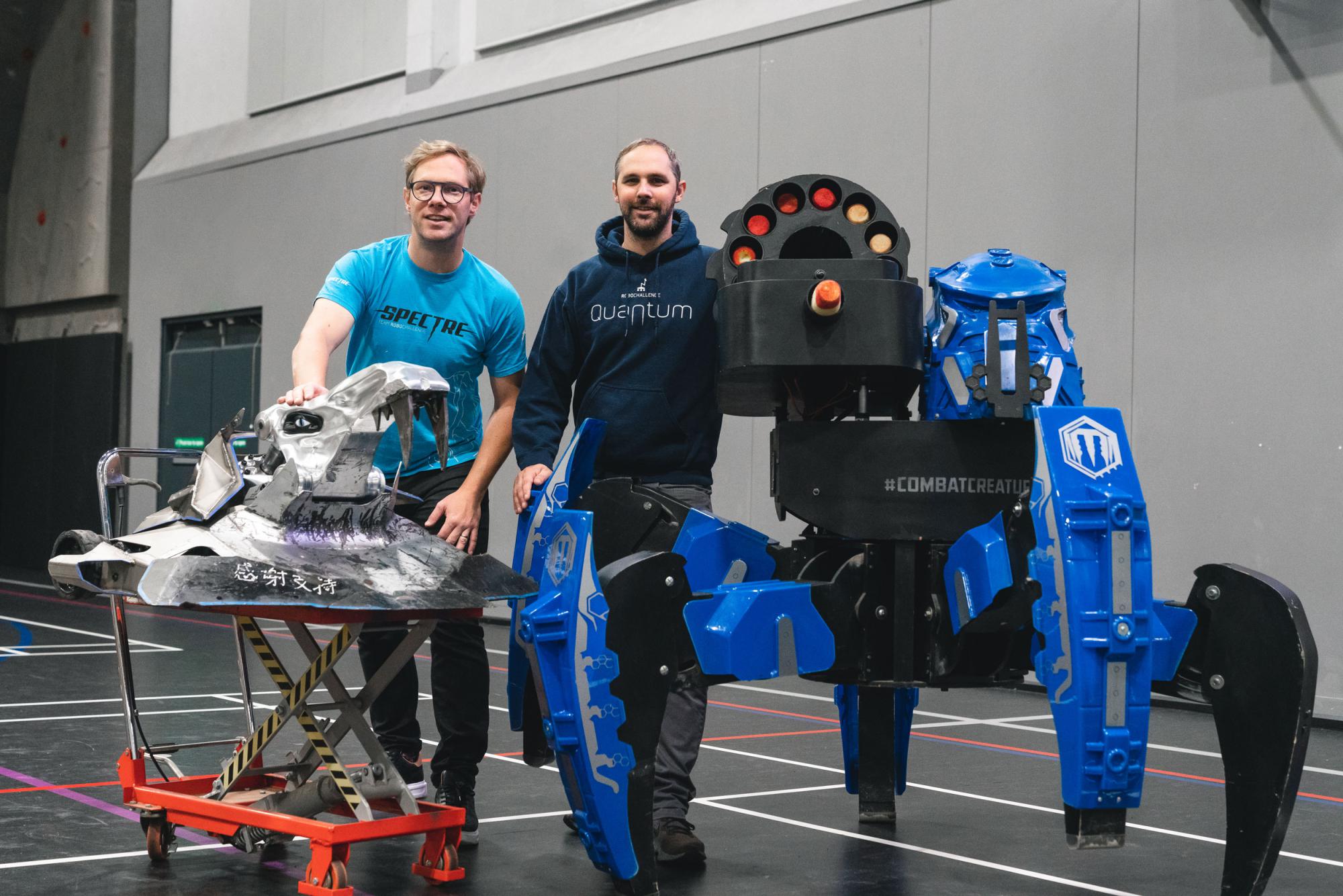 James and Grant Cooper stand with two of their custom built robots, including China's Battle of the Bots Champion Spectre