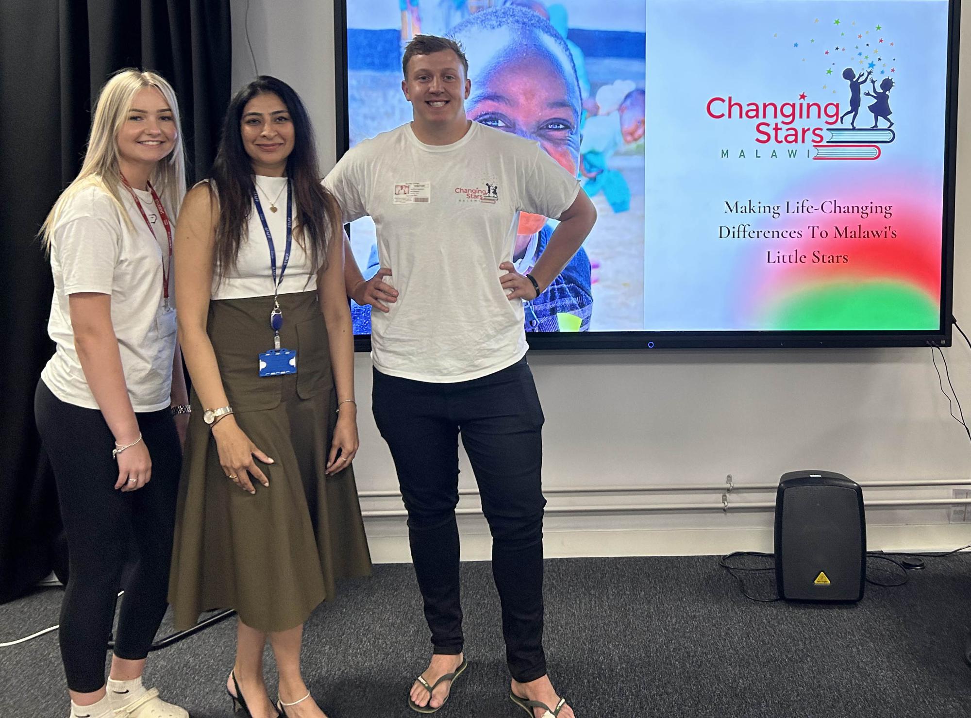 Three people in front of an electronic whiteboard