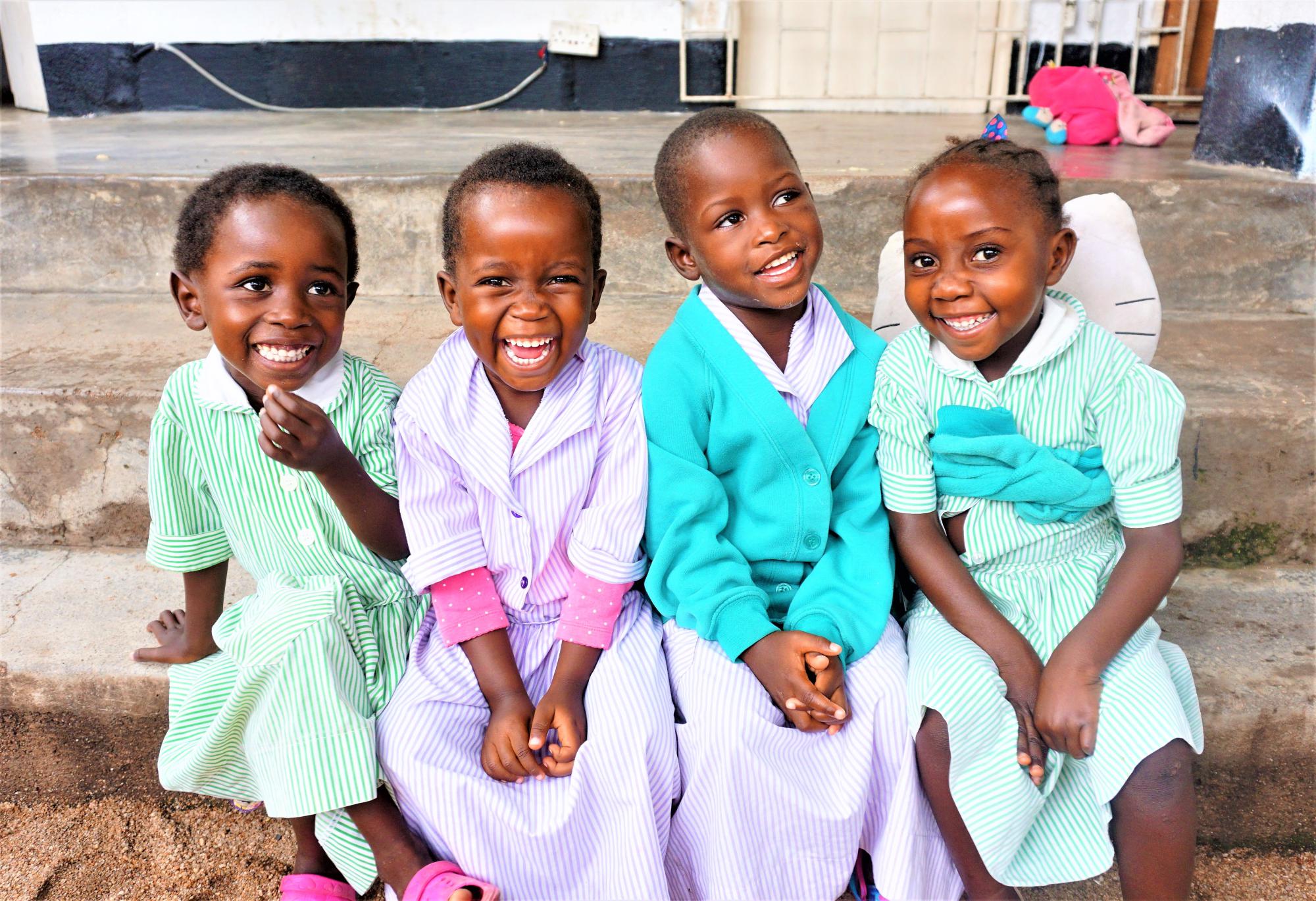 Four Malawian children smile at the camera`