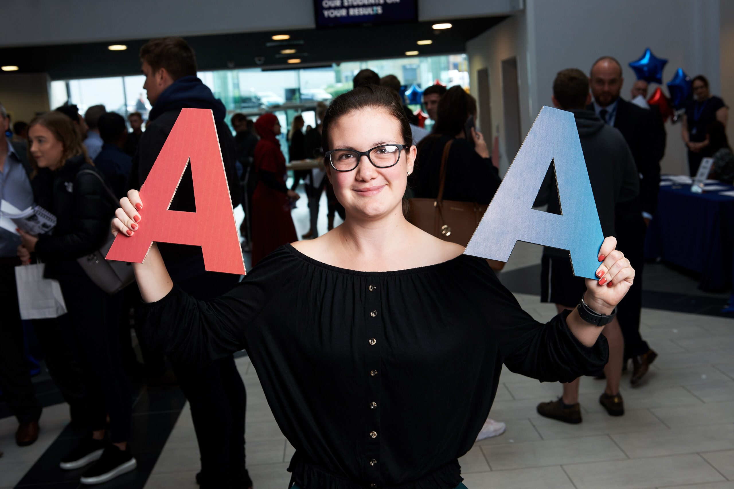 Chloe Bond A Level Results Day Chloe holding up 2 letter A's on her results day
