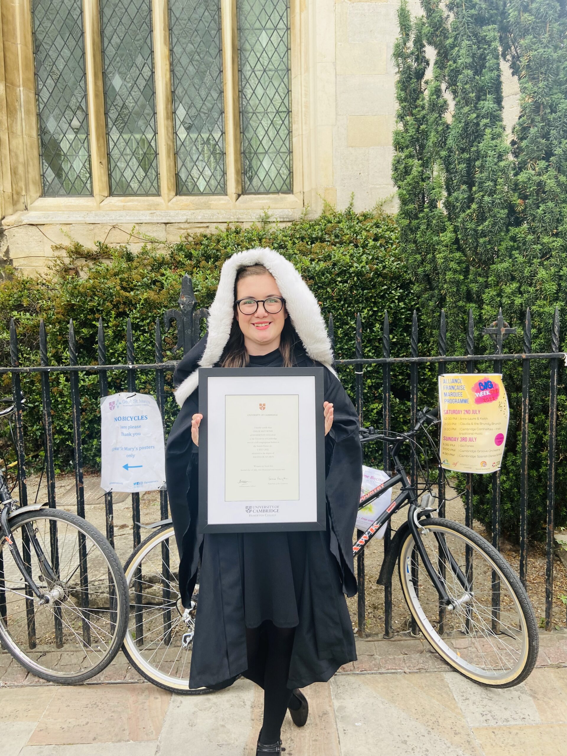 Chloe Bond Cambridge Graduation Chloe stood wearing her graduation gowns and holding certificate