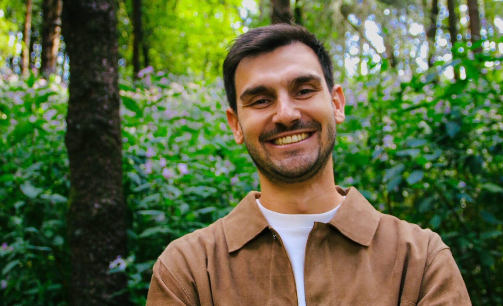 a man standing in woodland smiling